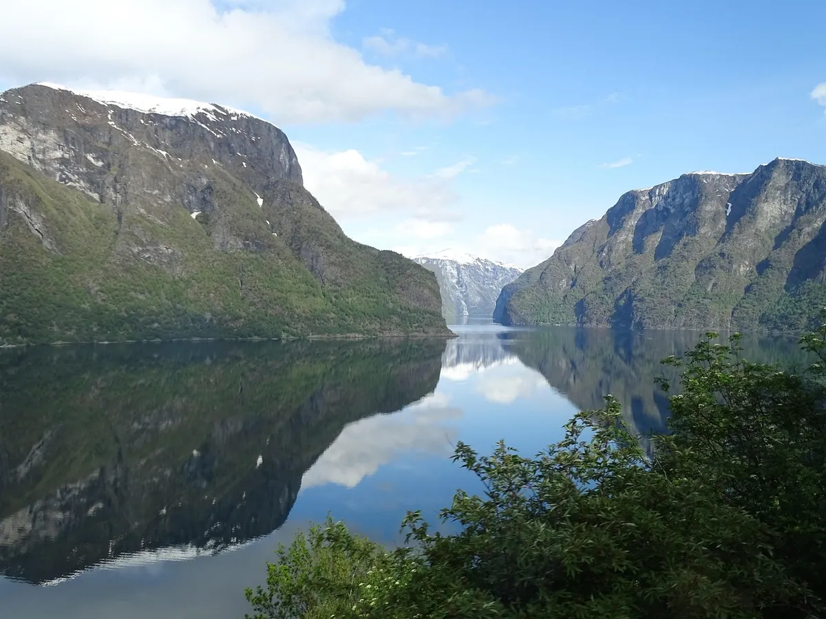 Steep fjord walls dropping to still water in western Norway